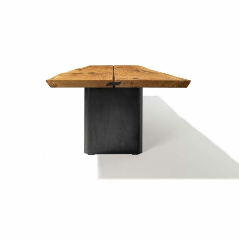 Team 7 „echt.zeit” Esstisch mit einer Tischplatte aus Massivholz in Eiche urig gebürstet und geölt sowie einem Metallwangengestell in Schwarz brüniert in frontaler Ansicht.