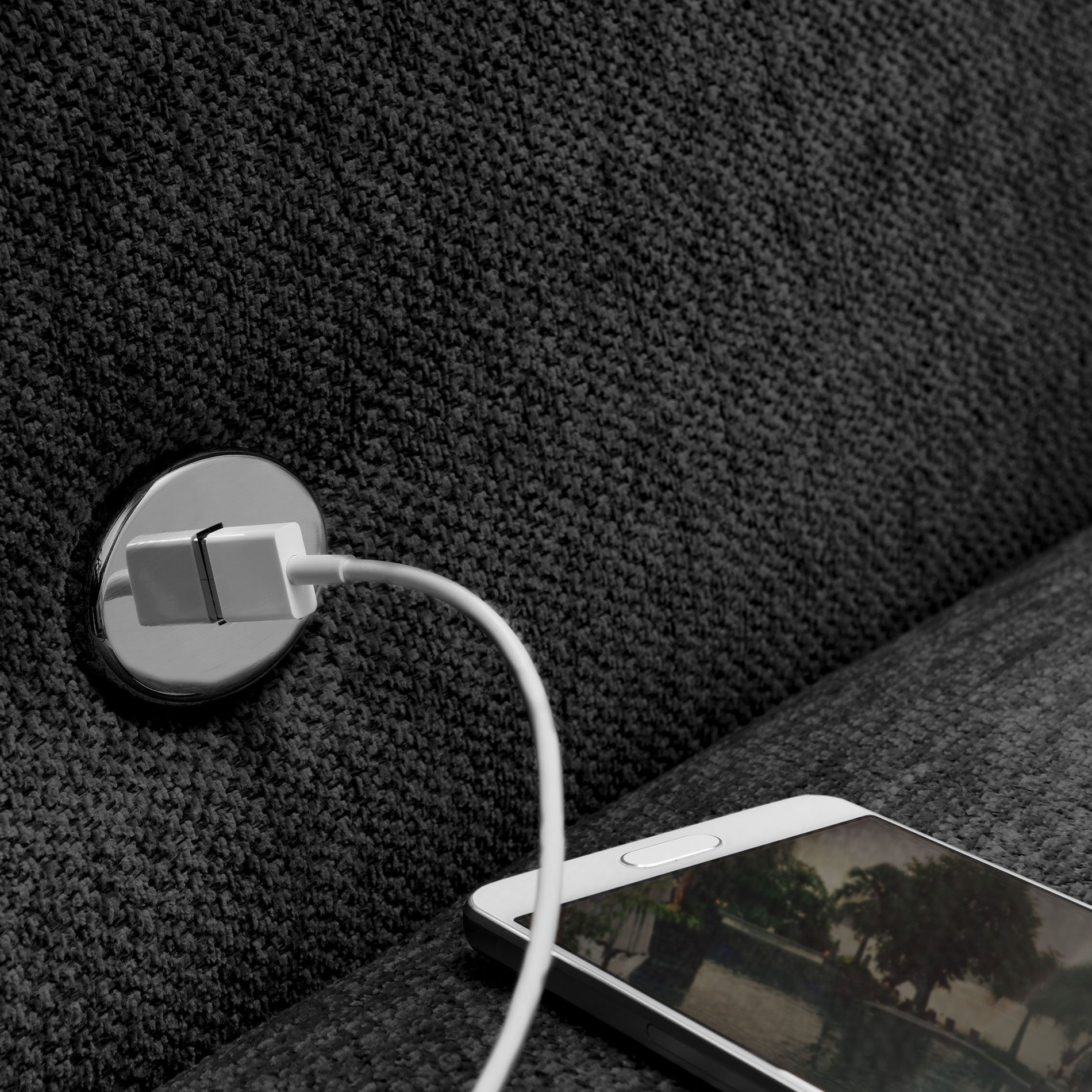 set one by Musterring 1300 Sofa mit Bezug Anthracite Grey zeigt USB-Anschluss.