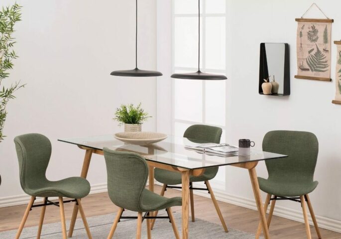 Esstisch mit Holzbeinen und Glasplatte, sowie vier Stühle mit grünem Stoffbezug und Holzbeinen